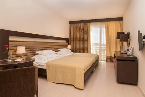 a hotel room with a large bed and a window at Hotel Garden Istra Plava Laguna in Umag