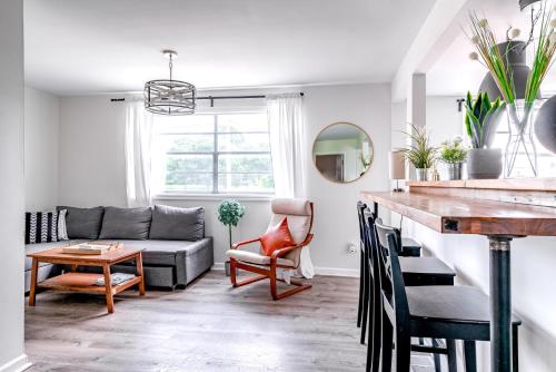 een woonkamer met een bank en een tafel bij Jungle House Columbus Short North Downtown Free Parking - Steps to Convention Center & Nationwide Arena - 1BR Luxury Home - Sleeps 6 - Over 5,800 Five Star Stays in Columbus