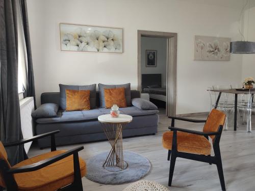 un soggiorno con un divano, un tavolo e delle sedie di Rondela Osijek a Osijek