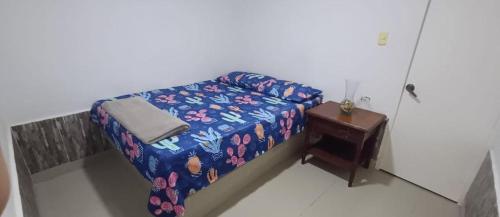 ein kleines Schlafzimmer mit einem Bett und einem Tisch in der Unterkunft Brisas de Uribia in Uribia