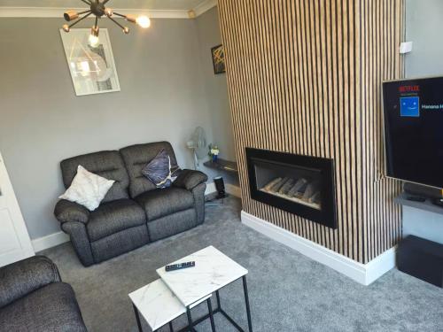 a living room with a couch and a fireplace at Aldwych house, For Holidays, Contractors & Relocation, Free Parking & Wi-Fi in Preston