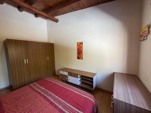 a bedroom with a red bed and a wooden cabinet at Cava del Sur in San Rafael
