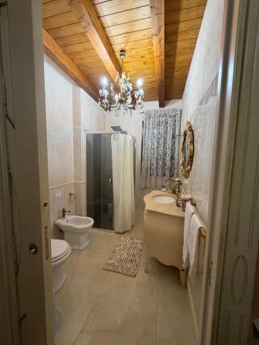 a bathroom with a sink and a toilet and a chandelier at B&B temptation in CTA