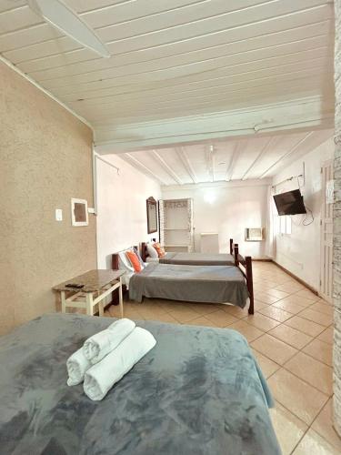 ein großes Zimmer mit zwei Betten und einem Fernseher in der Unterkunft Nova Aldeia Buzios in Búzios