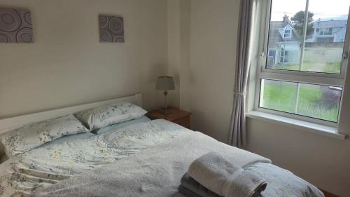 a bed in a bedroom with a window at Fairway Haven in Dunfanaghy