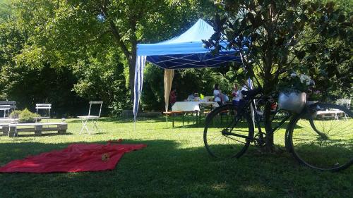 a bike parked under a blue tent in the grass at da Gastone in Rivignano