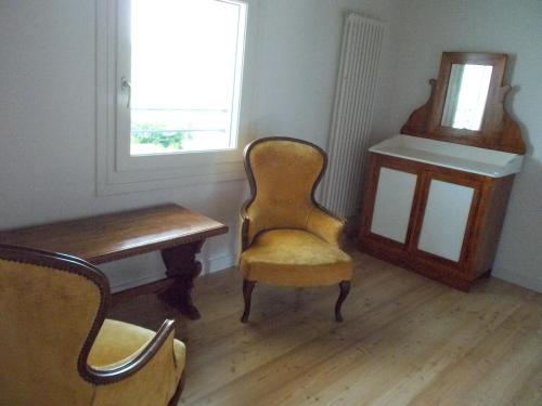 a room with a chair and a desk and a window at da Gastone in Rivignano