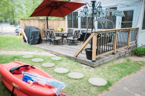 a patio with a table and an umbrella and a boat at Cottage on Crystal Beach 3BR & BBQ in Fort Erie
