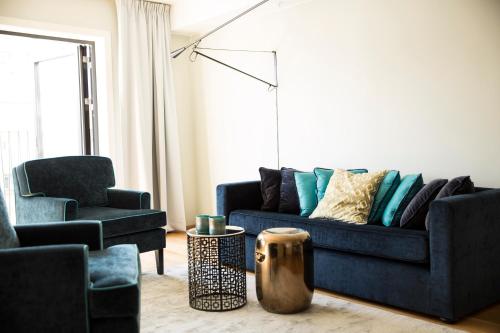 a living room with a blue couch and a chair at Frogner House - Vika in Oslo