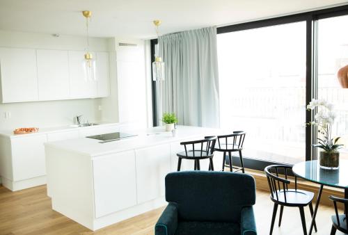 a kitchen with white cabinets and a table and chairs at Frogner House - Vika in Oslo