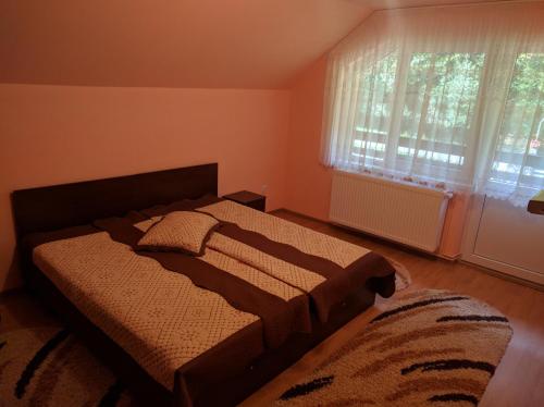 a bedroom with a bed and a window at Cabana Ovidiu in Râu de Mori