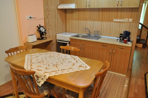 a kitchen with a wooden table and a sink at Cabana Ovidiu in Râu de Mori
