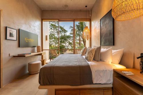 a bedroom with a large bed and a large window at 3086 - TreeTop Villa in Tangolunda