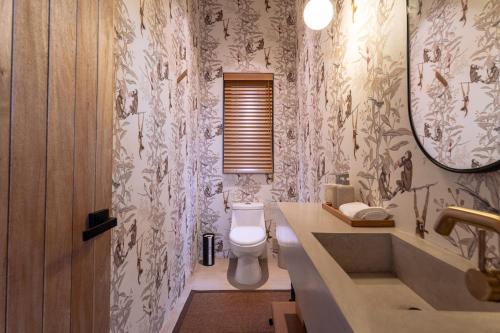 a bathroom with a toilet and a sink and a mirror at 3086 - TreeTop Villa in Tangolunda