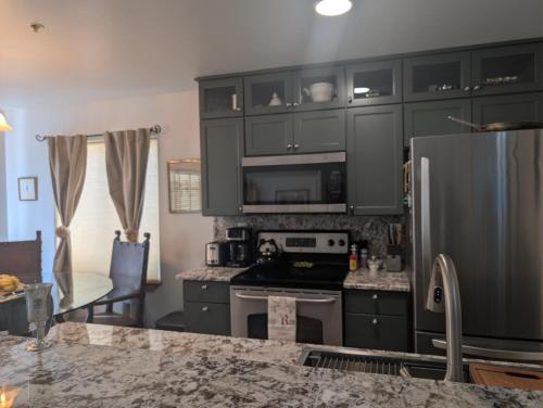 a kitchen with gray cabinets and a counter top at Peaceful Sunny Ski Out Ski In Condo, Parking, Pets in Telluride