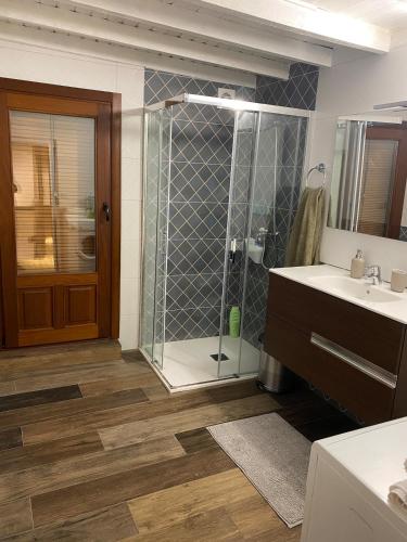 a bathroom with a shower and two sinks and a mirror at Casa Pueblo Anibal in Fermoselle
