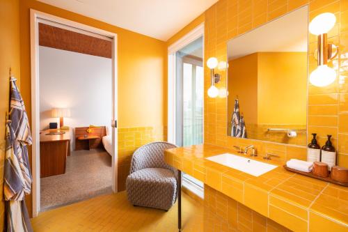 a yellow bathroom with a sink and a mirror at Hotel Magdalena in Austin