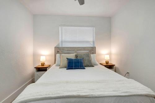a bedroom with a large white bed with two lamps at The Cozy Cove I 3 min to Beach in Bradenton