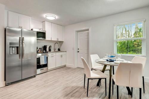 a kitchen with a table and a stainless steel refrigerator at The Cozy Cove I 3 min to Beach in Bradenton