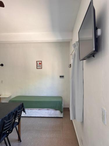 a room with a green bed and a tv at Brusa1 in Las Grutas