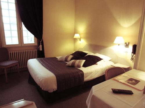A bed or beds in a room at Hotel Restaurant de la Marne