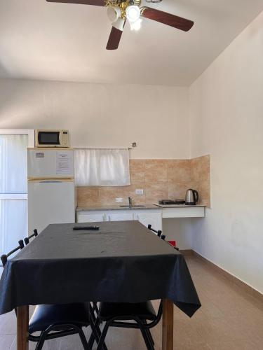 a kitchen with a table and a ceiling fan at Brusa1 in Las Grutas
