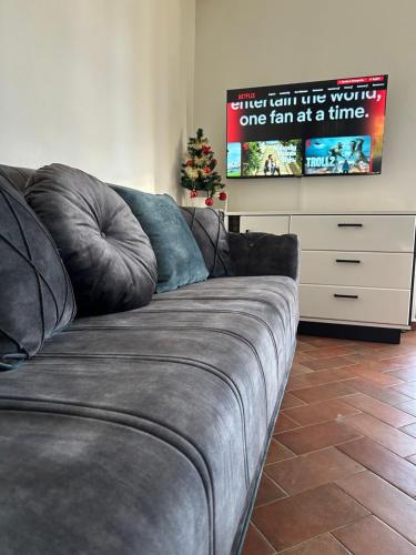 a gray couch in a living room with a christmas tree at Villa Ela in Prijedor