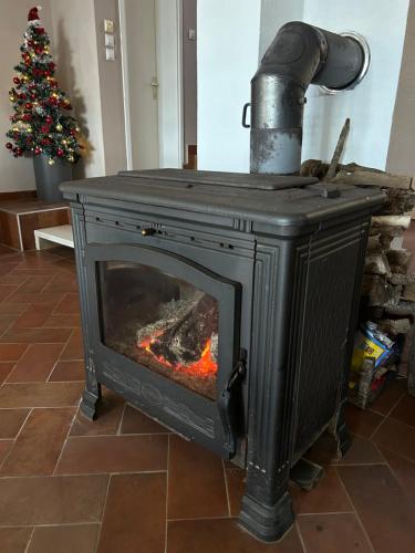 a stove with a fire in a room with a christmas tree at Villa Ela in Prijedor