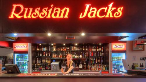 a woman standing at the bar of a russian jacks restaurant at Halls Creek Motel in Halls Creek