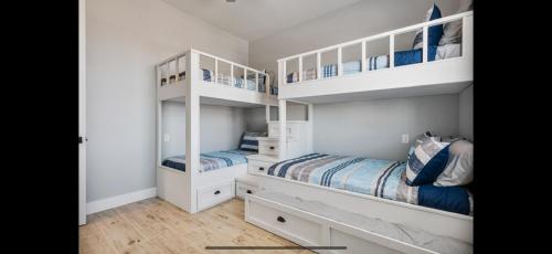 two white bunk beds in a white room at Perfect Beach Getaway Home! in Crystal Beach