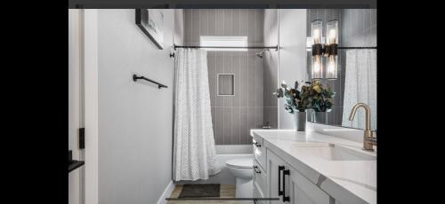 a white bathroom with a toilet and a sink at Perfect Beach Getaway Home! in Crystal Beach
