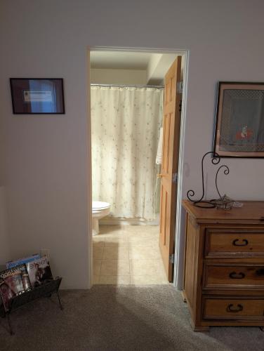 a bathroom with a toilet and a dresser with a television at Peaceful Sunny Ski Out Ski In Condo, Parking, Pets in Telluride