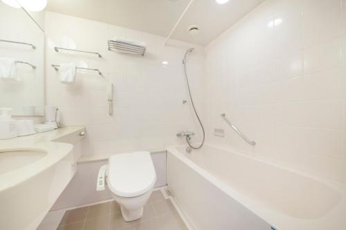 Baño blanco con aseo y lavamanos en Quintessa Hotel Sasebo en Sasebo