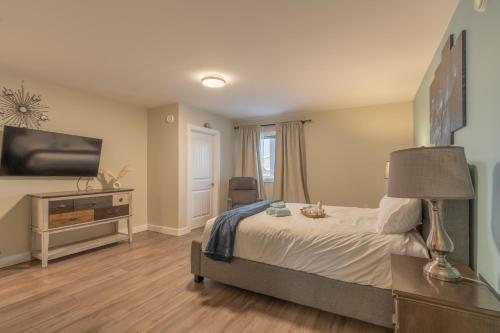 een slaapkamer met een bed en een flatscreen-tv bij Comfort Tenacity in Yellowknife
