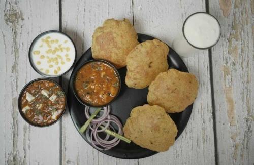 un piatto di cibo con del cibo su un tavolo di Hotel Paris Chandigarh Zirakpur a Zirakpur