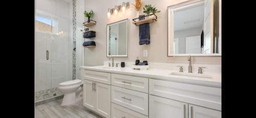 a bathroom with a sink and a toilet and a mirror at Stunning Beach Front House in Crystal Beach