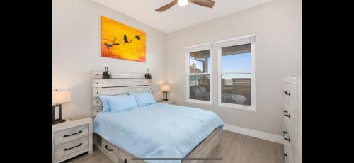 a bedroom with a bed and a dresser and a window at Stunning Beach Front House in Crystal Beach