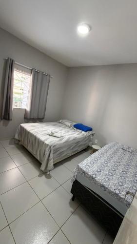 una camera da letto con due letti e una finestra di Paulinos Flat 02, Ubajara CE a Ubajara