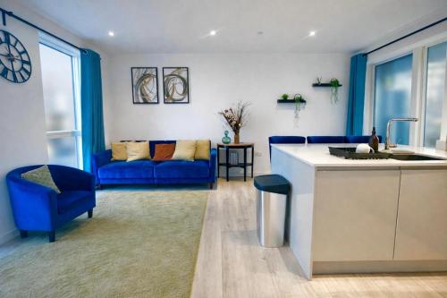 a kitchen and living room with a blue couch at Executive 3-Bed 2-Bath Apartment Central London in North Woolwich