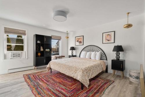 a white bedroom with a bed and a rug at The Return to Self - Walk to Historic Downtown in Warren