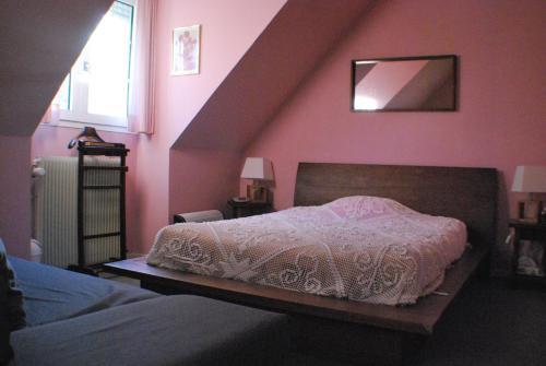 a bedroom with a bed with a white comforter at La Rachère in Vayres-sur-Essonnes