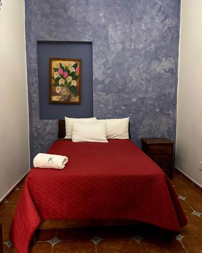 a bedroom with a bed with a red blanket at Plaza Real Hotel Boutique in Coscomatepec de Bravo