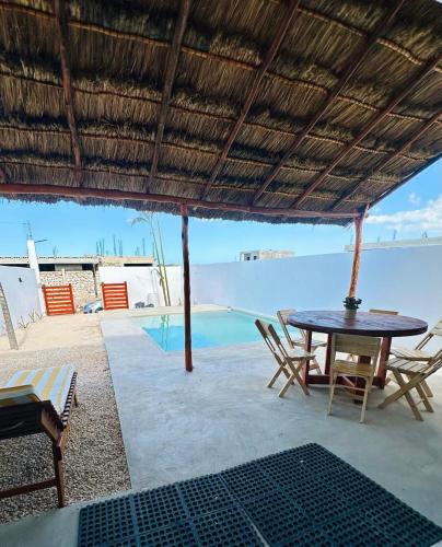 a patio with a table and chairs and a pool at La Conchita de Sisal 7 in Sisal