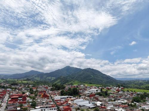 een stad onder een bewolkte hemel met bergen op de achtergrond bij Plaza Real Hotel Boutique in Coscomatepec de Bravo