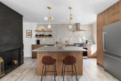 a kitchen with a island with two bar stools at The Return - Multi-Unit Retreat - Sleeps 16 - Spa in Warren