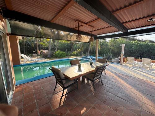 een terras met een tafel en stoelen en een zwembad bij Casa de la Roca in Mojón