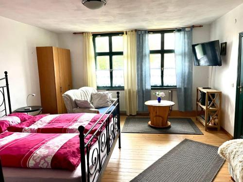 a bedroom with a bed and a couch and windows at Apartment Spitzwegerich by Interhome in Kappe