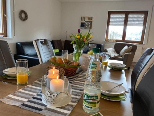 a dining room table with a candle and a bottle at Apartment Gästehaus Siebert by Interhome in Bad Brambach