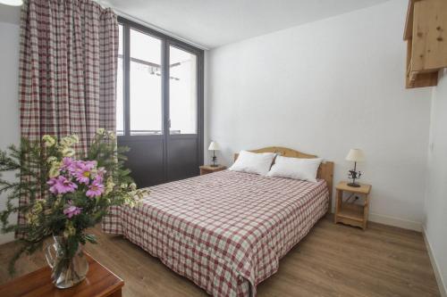 ティーニュにあるRésidence Odalys Le Rond Point Des Pistesのベッドルーム1室(ベッド1台、赤と白の毛布付)