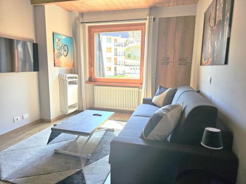 a living room with a blue couch and a table at Moda Apartments 69 in Sestriere